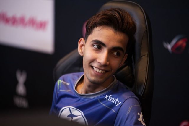 Dota 2 player SumaiL sitting back in a gaming chair, smiling. 