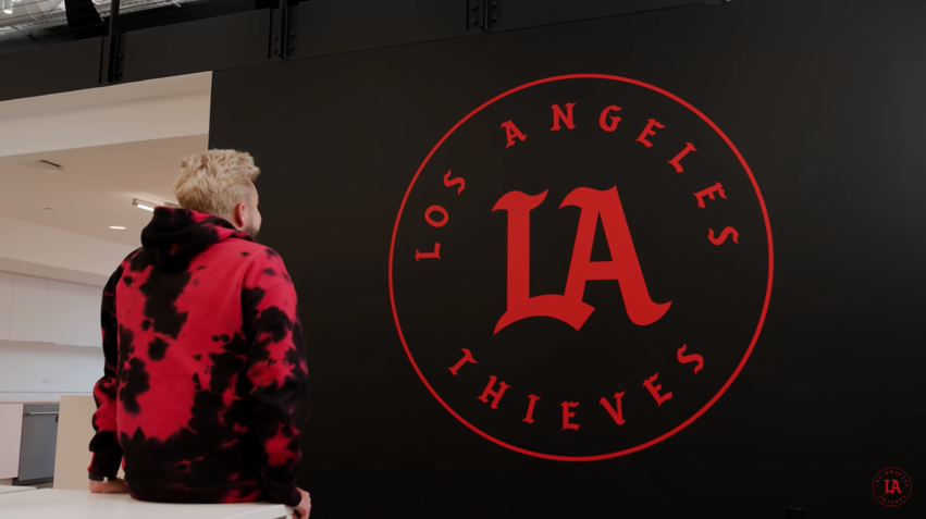 100 Thieves owner looking at LA Thieves logo on a wall.