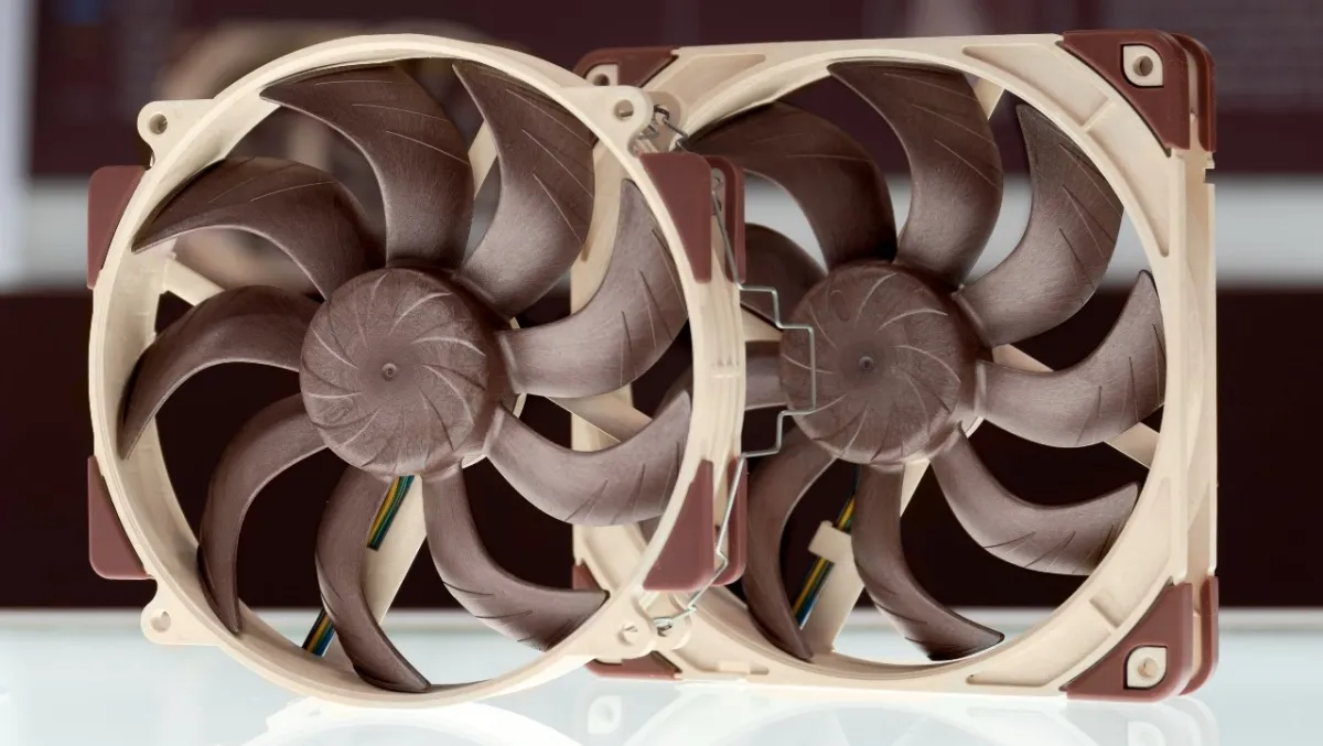 Two brown Noctua static pressure fans on white surface with blurred background