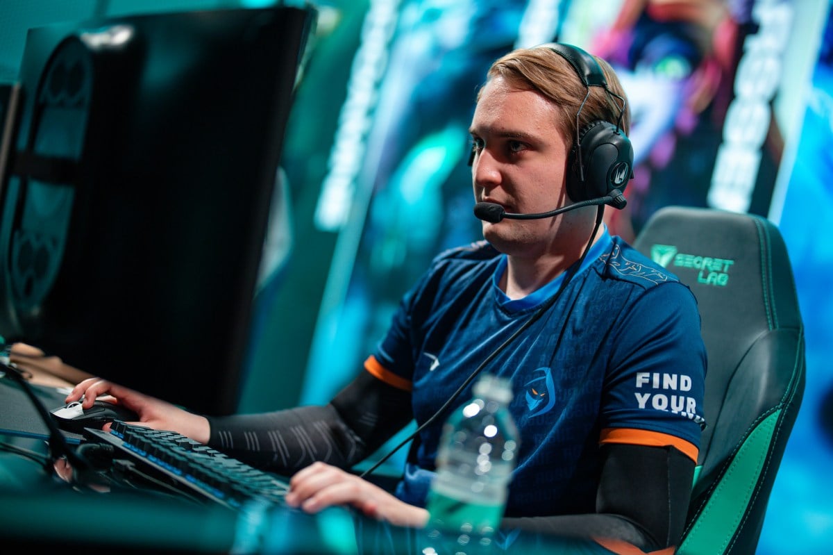 LoL pro Trymbi competing on stage in the LEC, wearing a blue Rogue jersey.