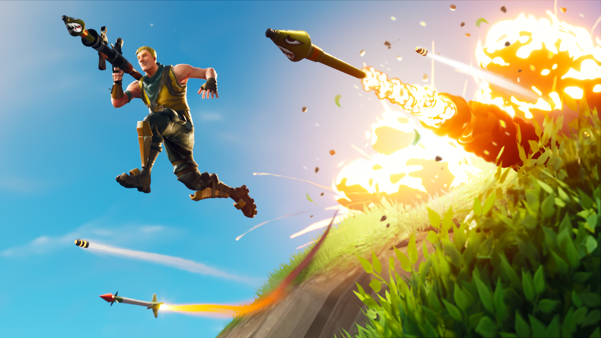 A player leaps with a rocket launcher away from an explosion in Fortnite