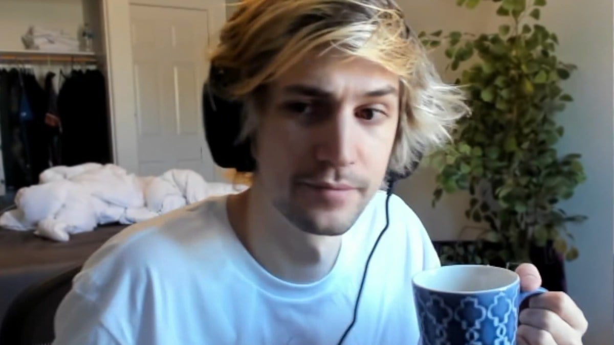 xQc looks at camera with mug in hand.