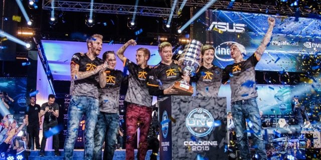 JW from fnatic holding the ESL One Cologne 2015 trophy while confetti is falling on the stage.