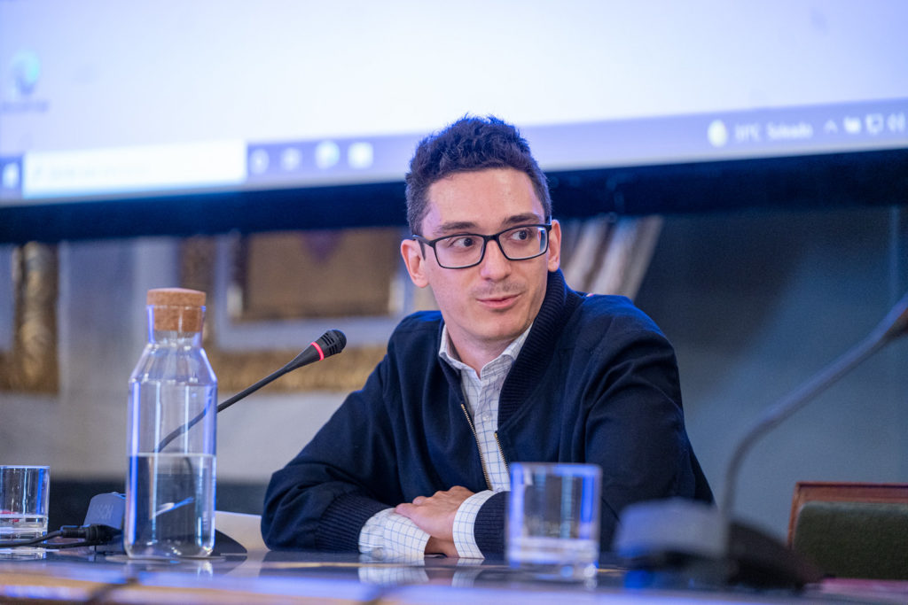 Fabiano Caruana sits at a press conference answering chess-related questions.