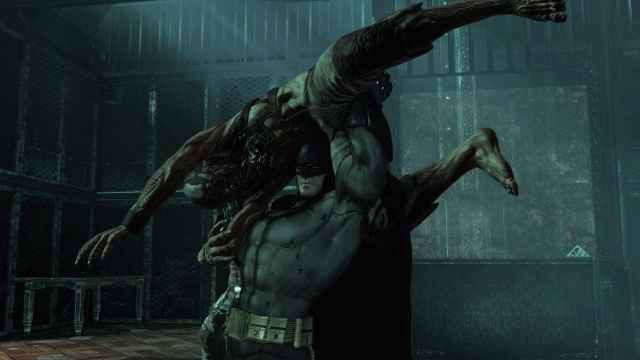 Batman lifts an enemy over his head in a house in Batman: Arkham Asylum.