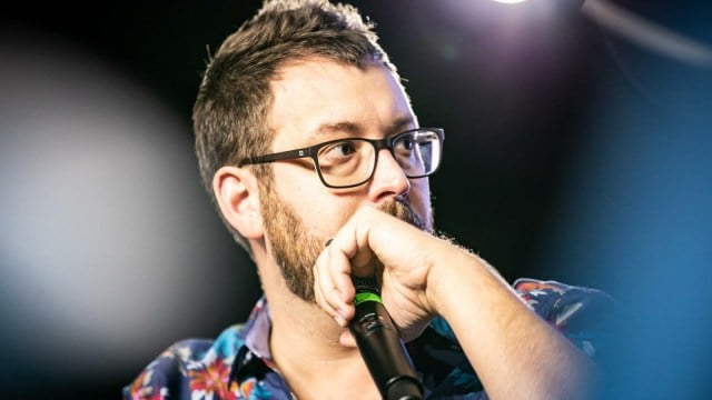 Twitch Streamer Gothalion holding a microphone looking to the side