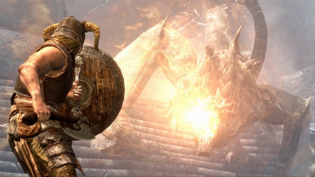 the dragonborn wearing a helmet and hide armour raises a shield to protect from a dragon's flames