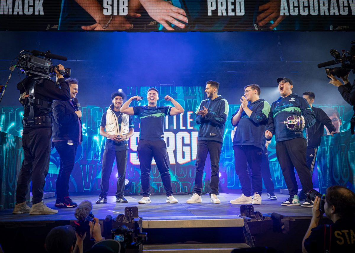 Seattle Surge's Pred flexes on the CDL stage surrounded by his teammates.