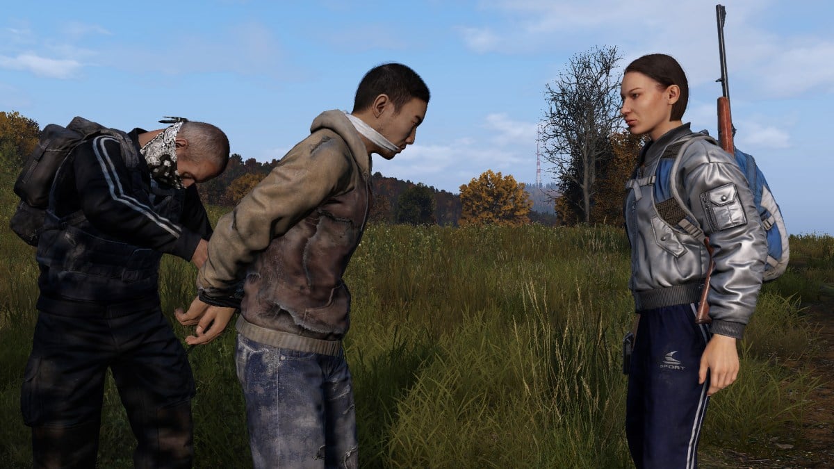 One DayZ player handcuffing another while a third watches