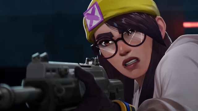 Killjoy, an agent from VALORANT, wields her gun while wearing glasses and her iconic yellow beanie.