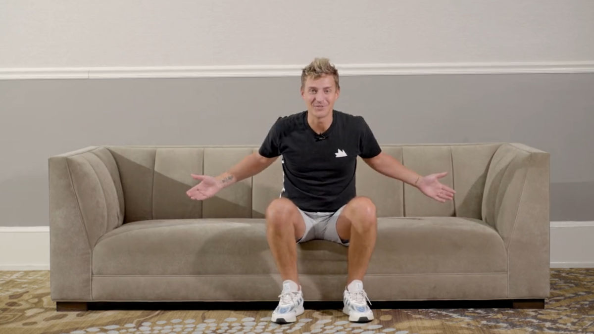 Ninja sitting on a couch with his arms open.