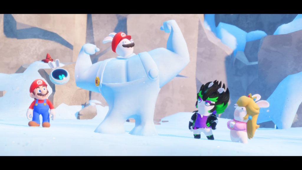 Rabbid Mario flexes behind a muscular snow sculpture while Mario, Rabbid peach, and Edge look at him increduosly