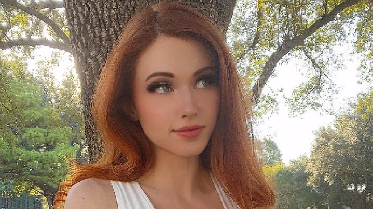 Amouranth standing near a tree.
