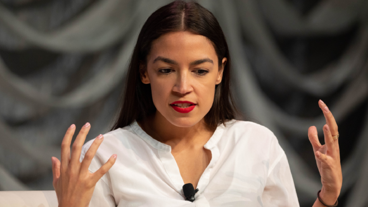 AOC with her hands spread wide apart as she emotes