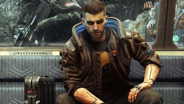 male V from the cyberpunk 2077 promos sat on a couch and looking at the camera defiantly