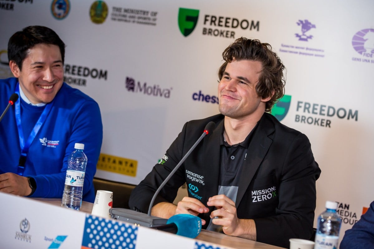 World chess number one Magnus Carlsen sits smiling at a press conference.