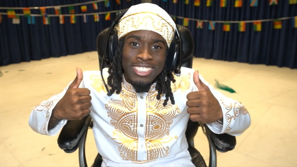 Streamer Kai Cenat giving the double thumbs up with a wide smile.