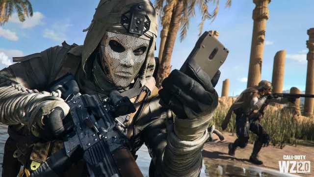 An operator in a white mask holds a phone and a gun while battling in Call of Duty.