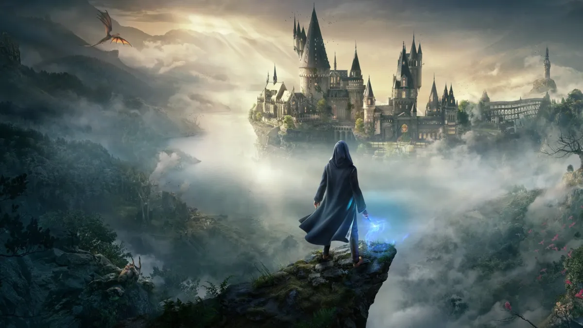 A wizard stands looking at Hogwarts in the distance