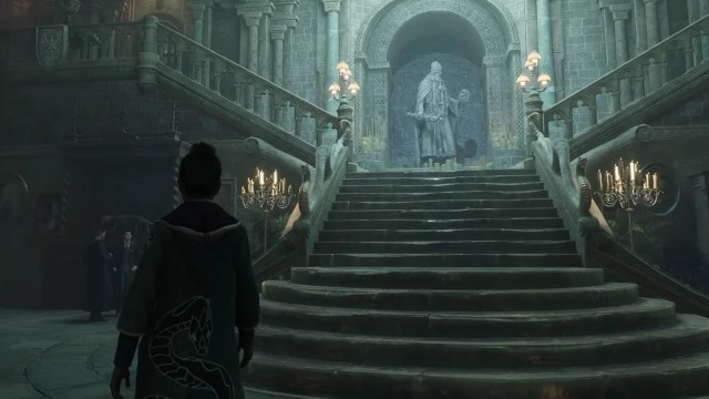 A player at the bottom of a staircase in Hogwarts Legacy.