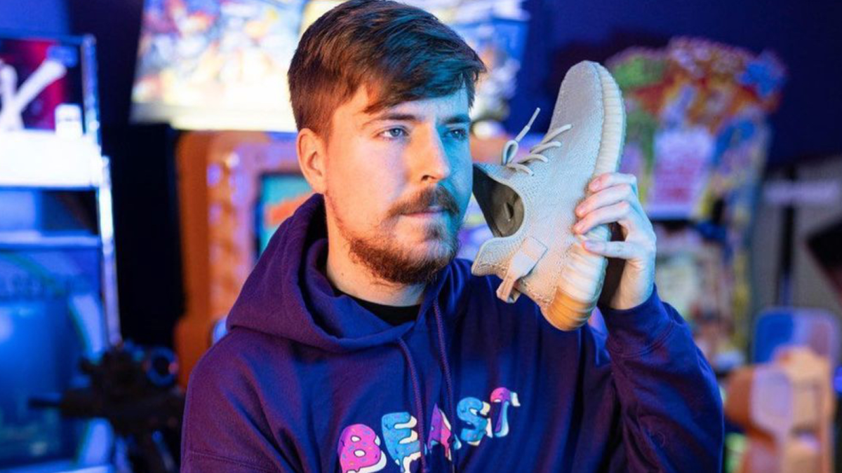 MrBeast holding a Yeezy trainer to his ear like a phone.