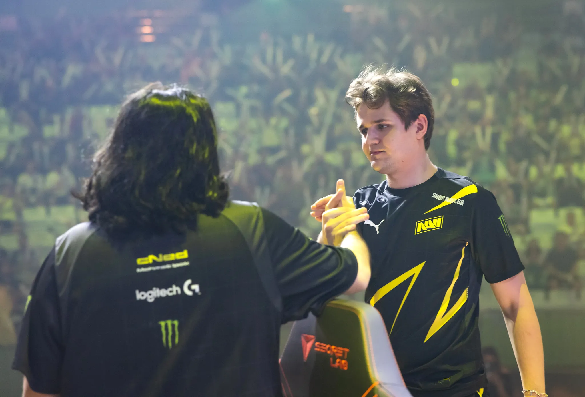 Shao shaking hands with another payer in a packed arena