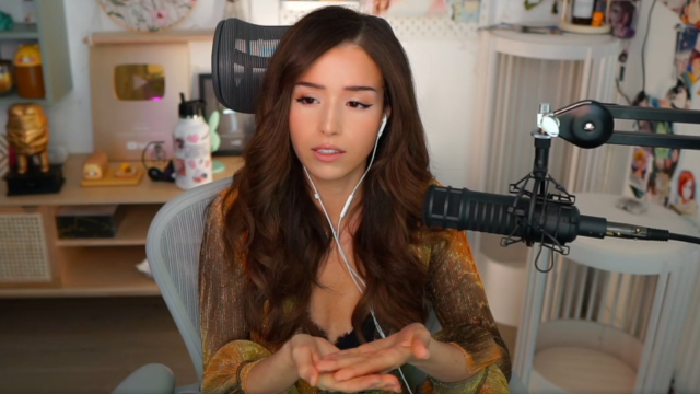 Pokimane sitting in front of a camera speaking into a microphone.