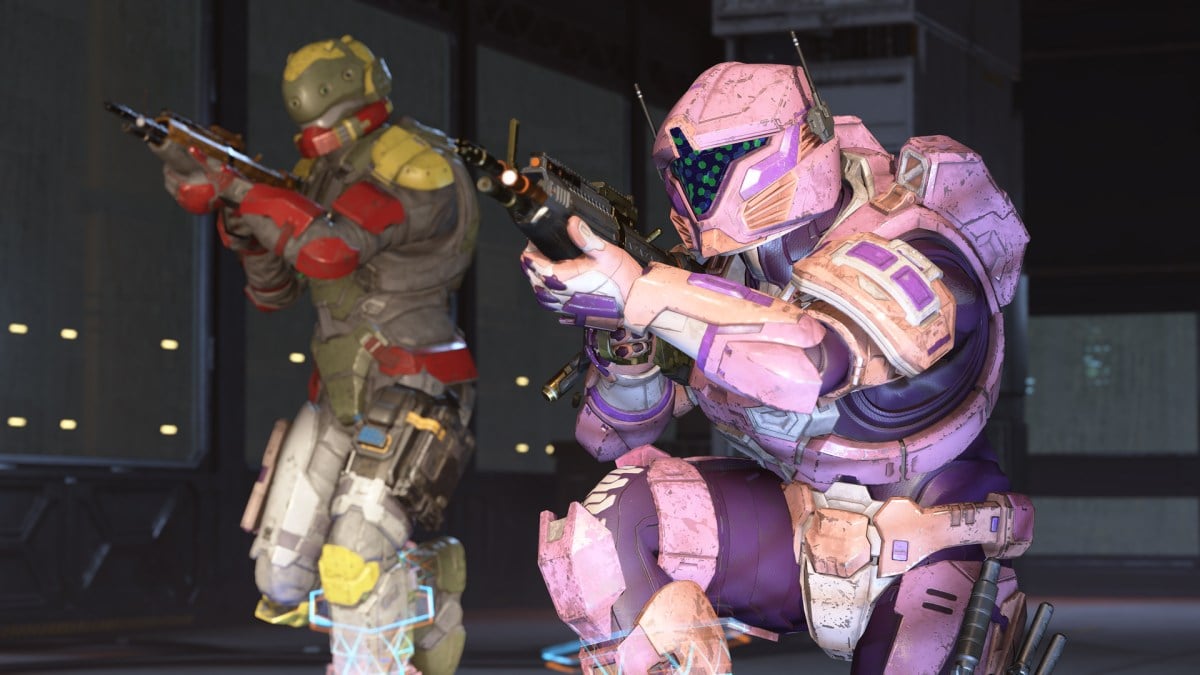 A pink Spartan crouches in front of another Spartan set up behind them.