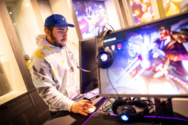 A man playing a game of League of Legends on a computer