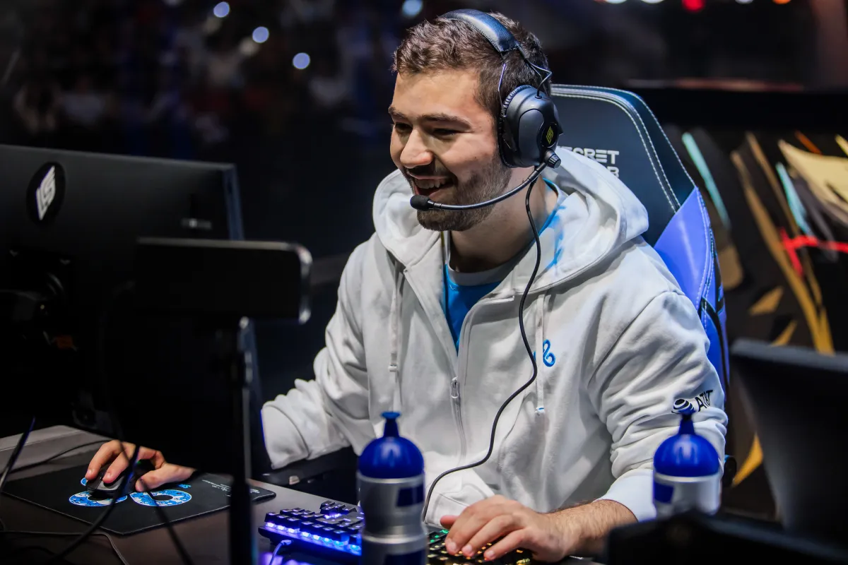 Cloud9's top laner Fudge sitting at his computer during the 2023 Spring Finals laughing.