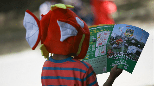 A young Pokemon fan looking at a pamphlet at Go Fest.