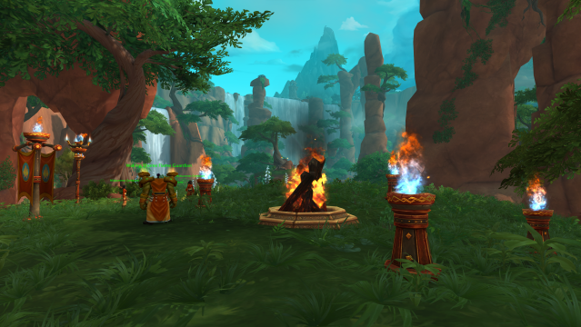 A WoW screenshot of an orc standing in front of a bonfire in the Waking Shores