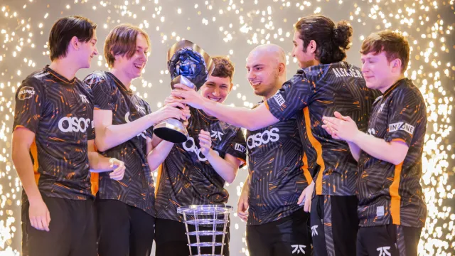 The Fnatic VALORANT team celebrating their victory at VCT Masters Tokyo, lifting the trophy while sparks fly in the background.