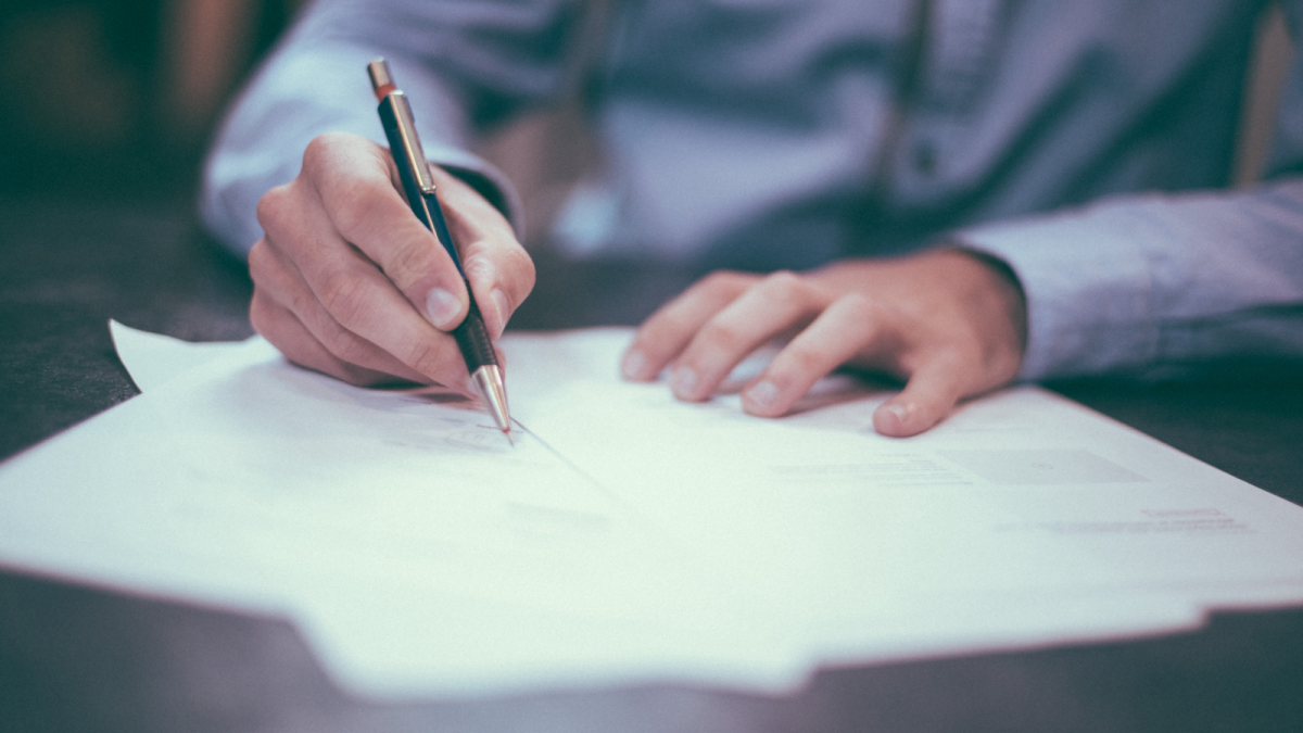 A person signing a contract.