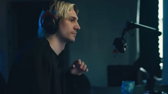 xQc sitting at his computer during the Kick announcement video.