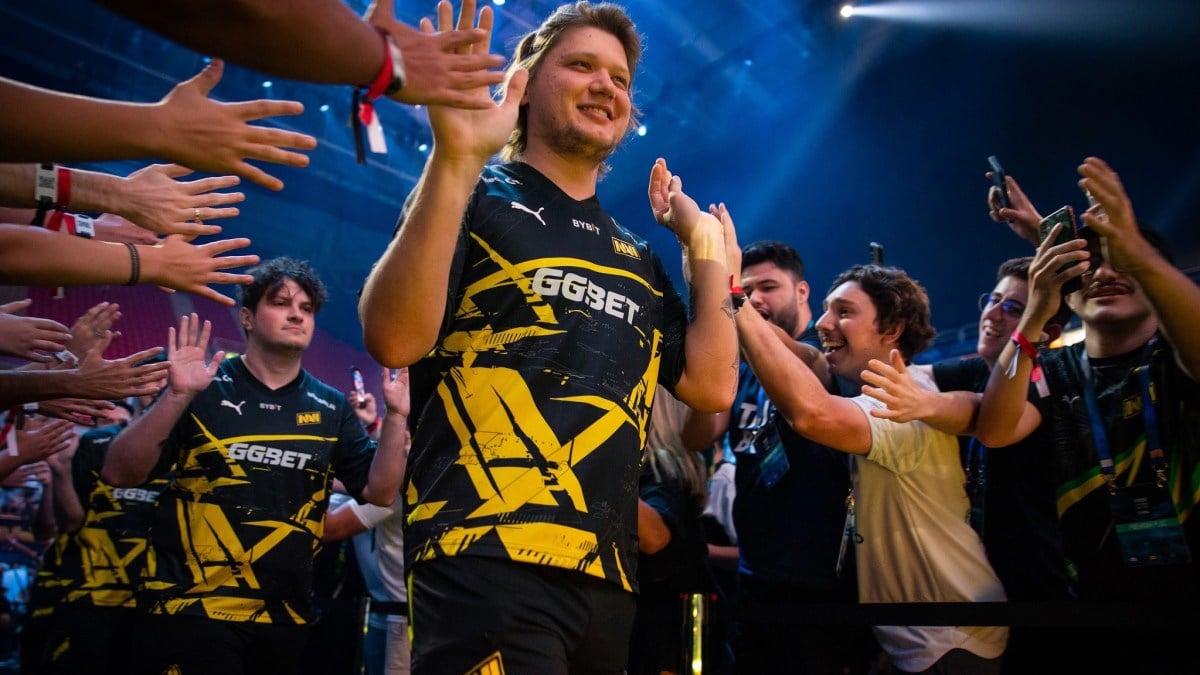 Professional CS:GO player s1mple walks to the stage of IEM Rio 2023 with a smile on his face.