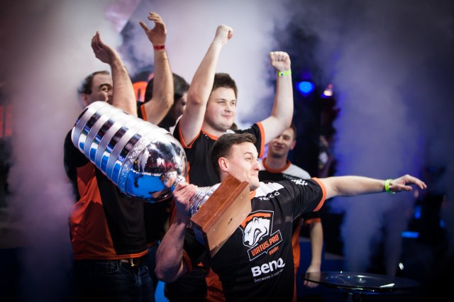 PashaBiceps hoisting a trophy after winning EMS One Katowice 2014 with the rest of Virtus Pro in the background.