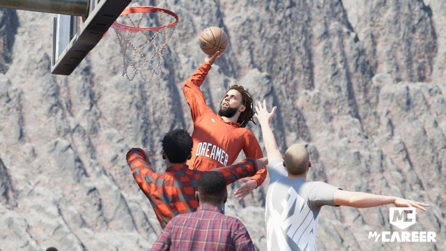 J. Cole goes for a dunk over several other players.