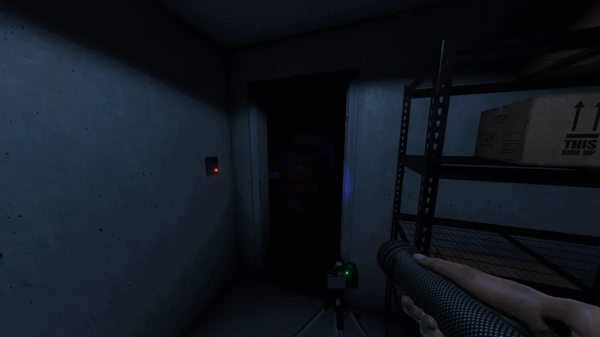 A Phasmophobia player holding up a flashlight in a dark room