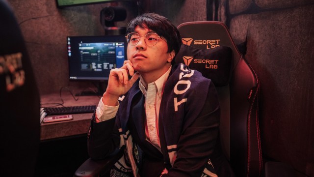 T1 coach Bengi sits in a chair at Worlds 2022.