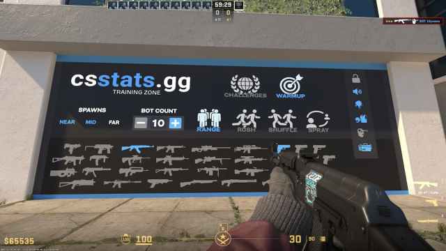 An AK-47 automatic rifle pointed at a wall filled with logos and silhouettes of various weapons in CS2.