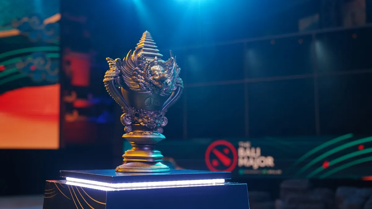 The trophy for the Dota 2 Bali Major, sitting on a plinth with the main stage of the tournament in the background.