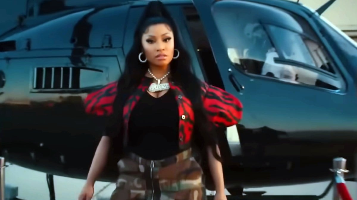 Niki Minaj standing in front of a helicopter.