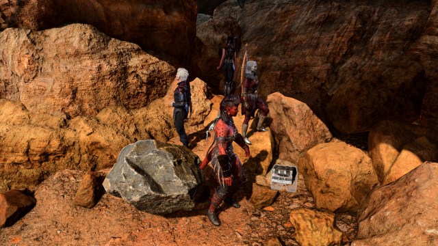 A party in Baldur's Gate 3 is shown standing on a rocky environment, with a chest. 