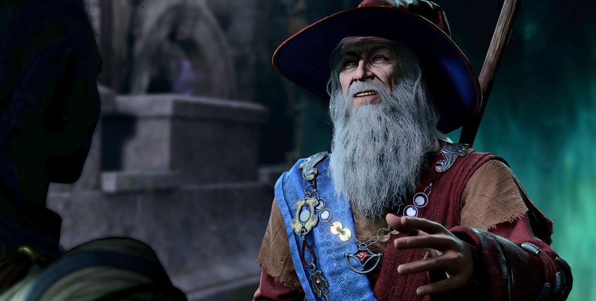 A Wizard in Baldur's Gate with a blue sash talks to a player.