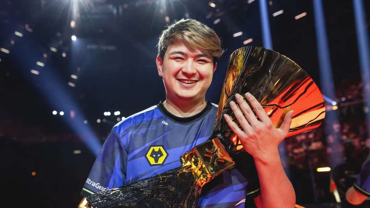 Corbin "C0M" Lee smiles while holding the 2023 VCT Champions trophy on stage in Los Angeles.