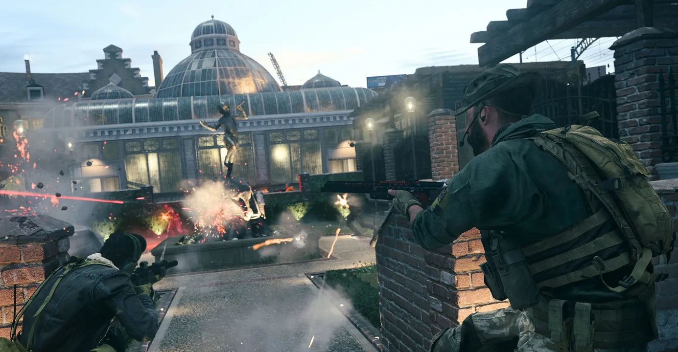 There are soldiers in a shootout with a large building in the background. There are explosions and other soldiers firing at them in the distance.
