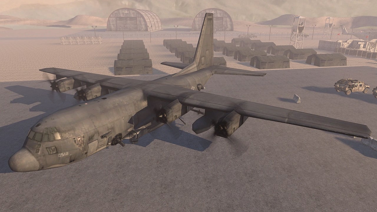 An AC-130 gunship is docked on an airport. There are bunkers in the distance behind it.