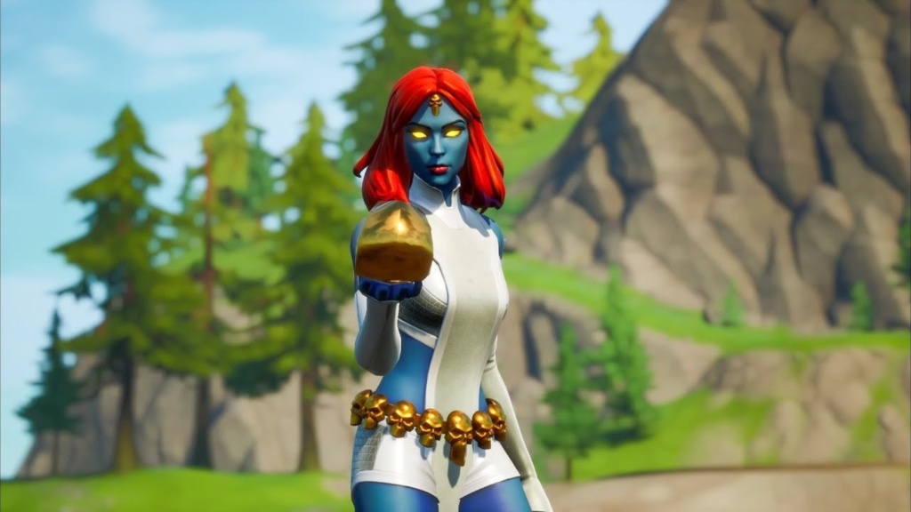 Mystique stands front and center unchanged in her white suit and red hair while holding a golden object in one hand.