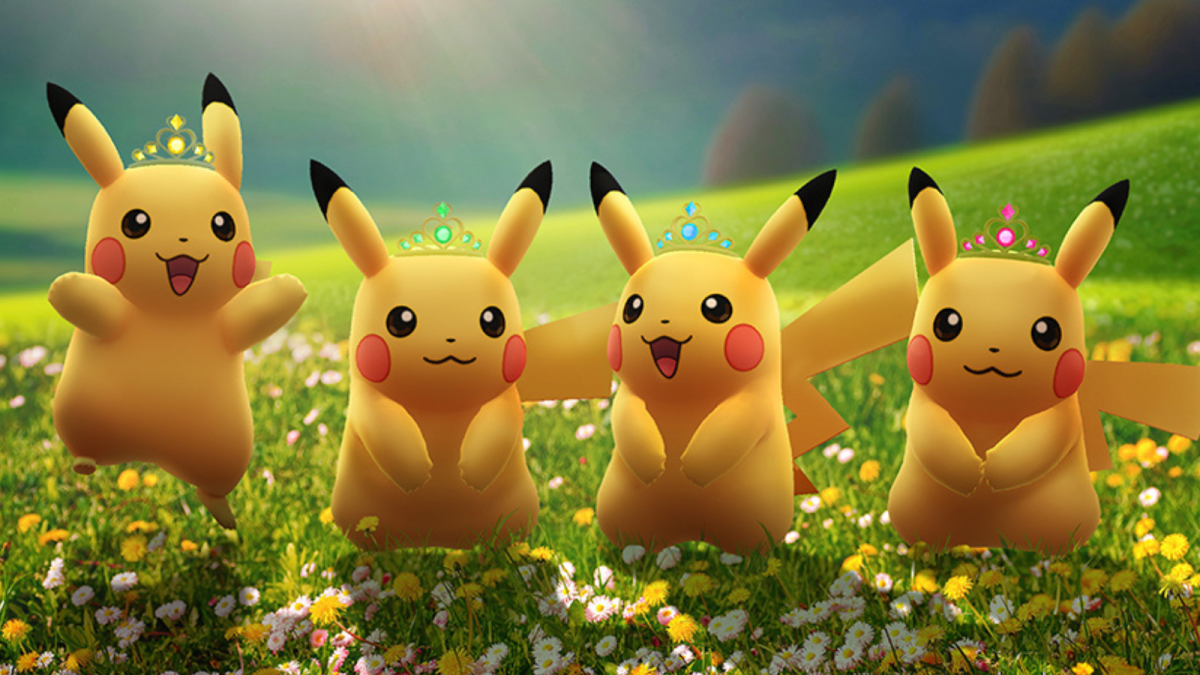 Four Pikachu wearing crowns in a grassy field in Pokémon Go.